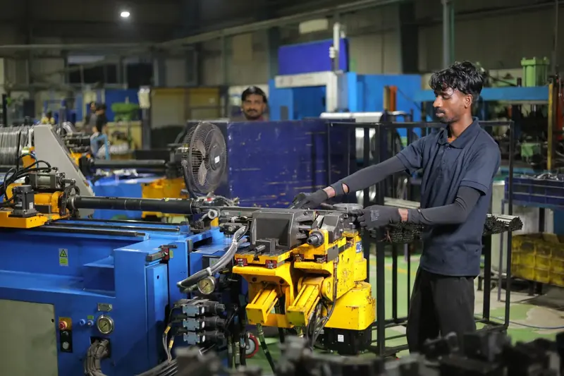 An operator working a CNC tube bending machine