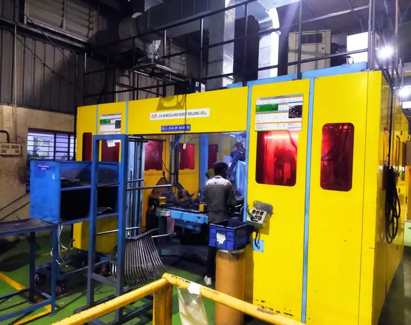 A yellow robotic welding cell
